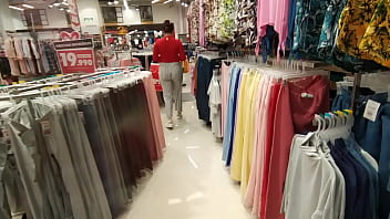 A mulher comprando a roupa e vestindo na loja